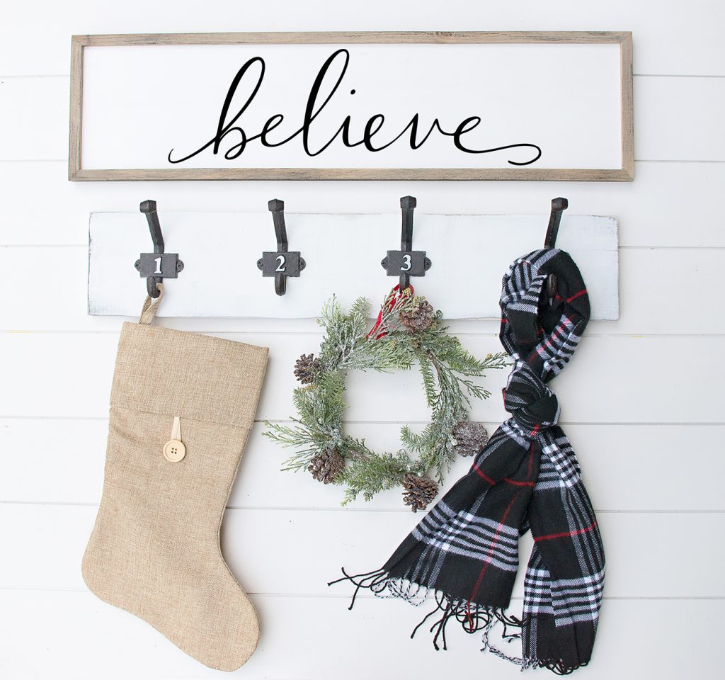 Download a FREE Believe Christmas SVG File by Pineapple Paper Co. - Believe Wood Sign hanging above hooks with stocking and scarf