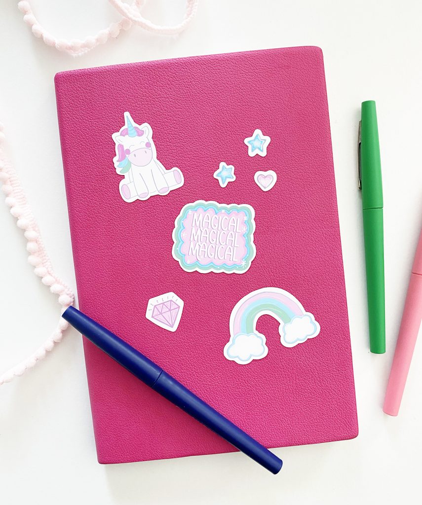 Free Printable Unicorn Stickers on a Pink Notebook