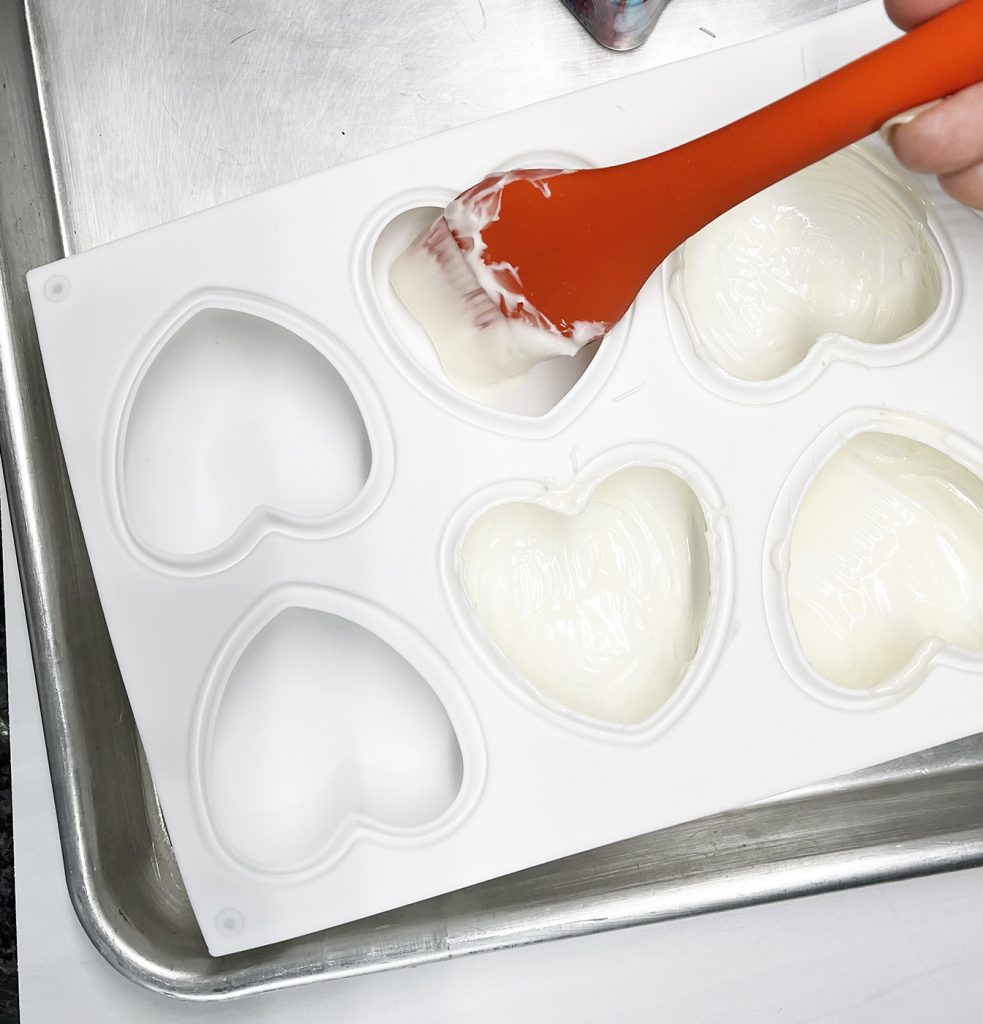 Brushing Chocolate into White heart shaped silicone mold