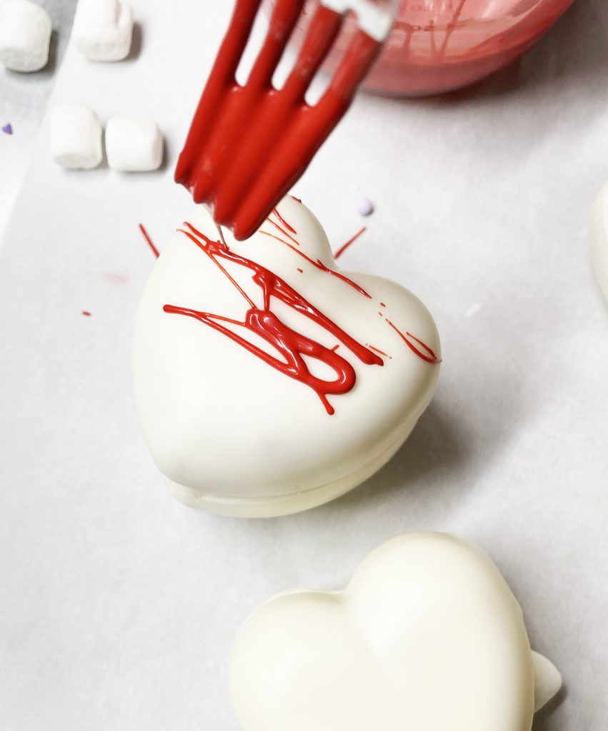 Drizzling Red Chocolate on Heart White Chocolate Hot Cocoa Bomb