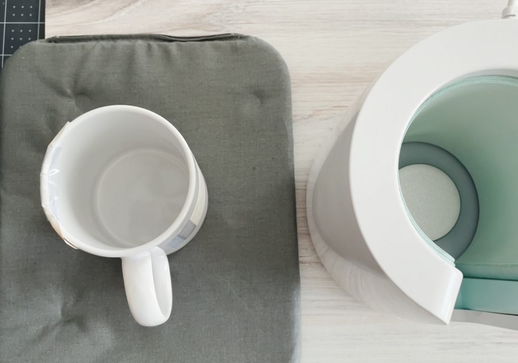 Sublimation Mug Cooling on Cricut Heating Mat next to Cricut Mug Press