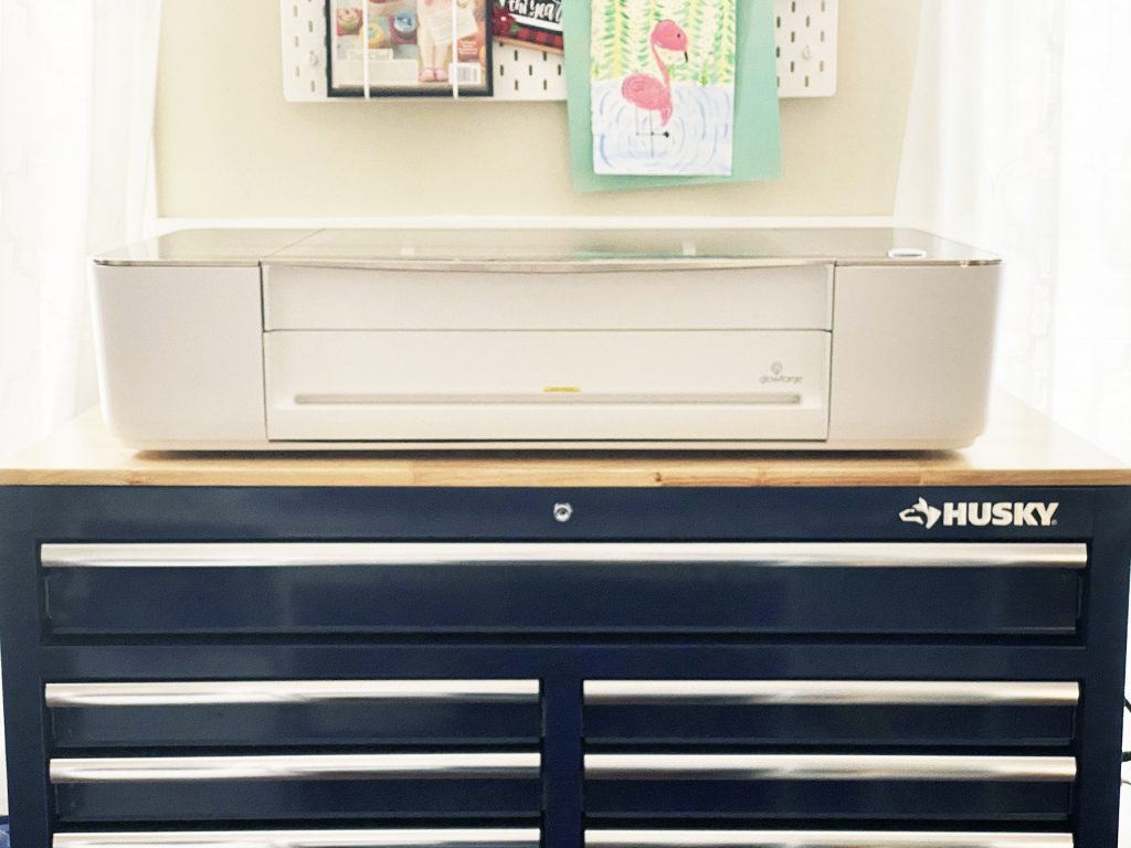 Glowforge 3d laser printer sitting on large husky blue workbench with drawers