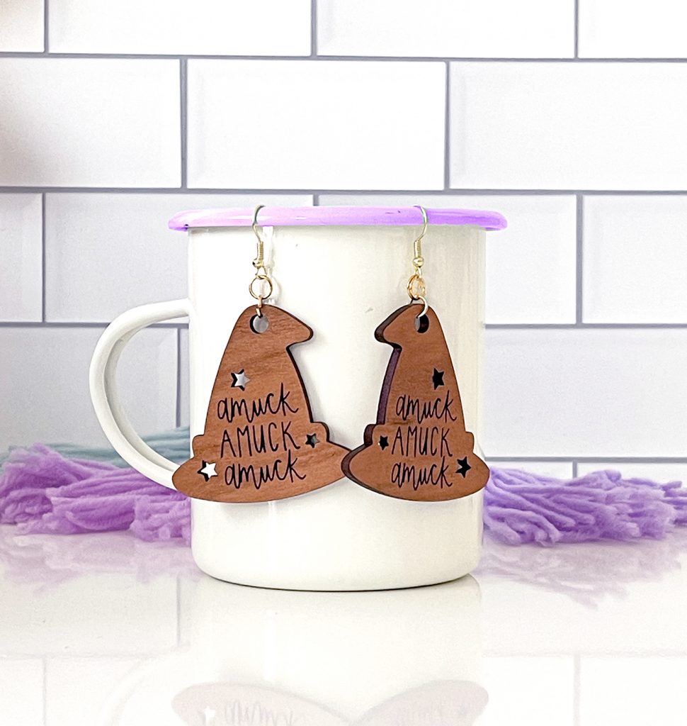 Laser Cut Wooden Halloween Earrings with Amuck Hanging on White Enamel Mug