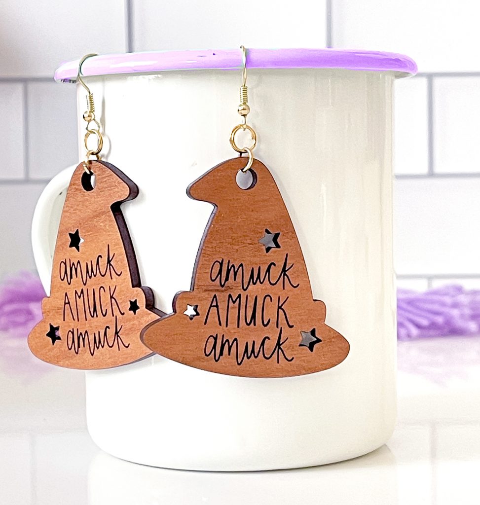 Laser Cut Wooden Halloween Earrings with Amuck Hanging on White Enamel Mug