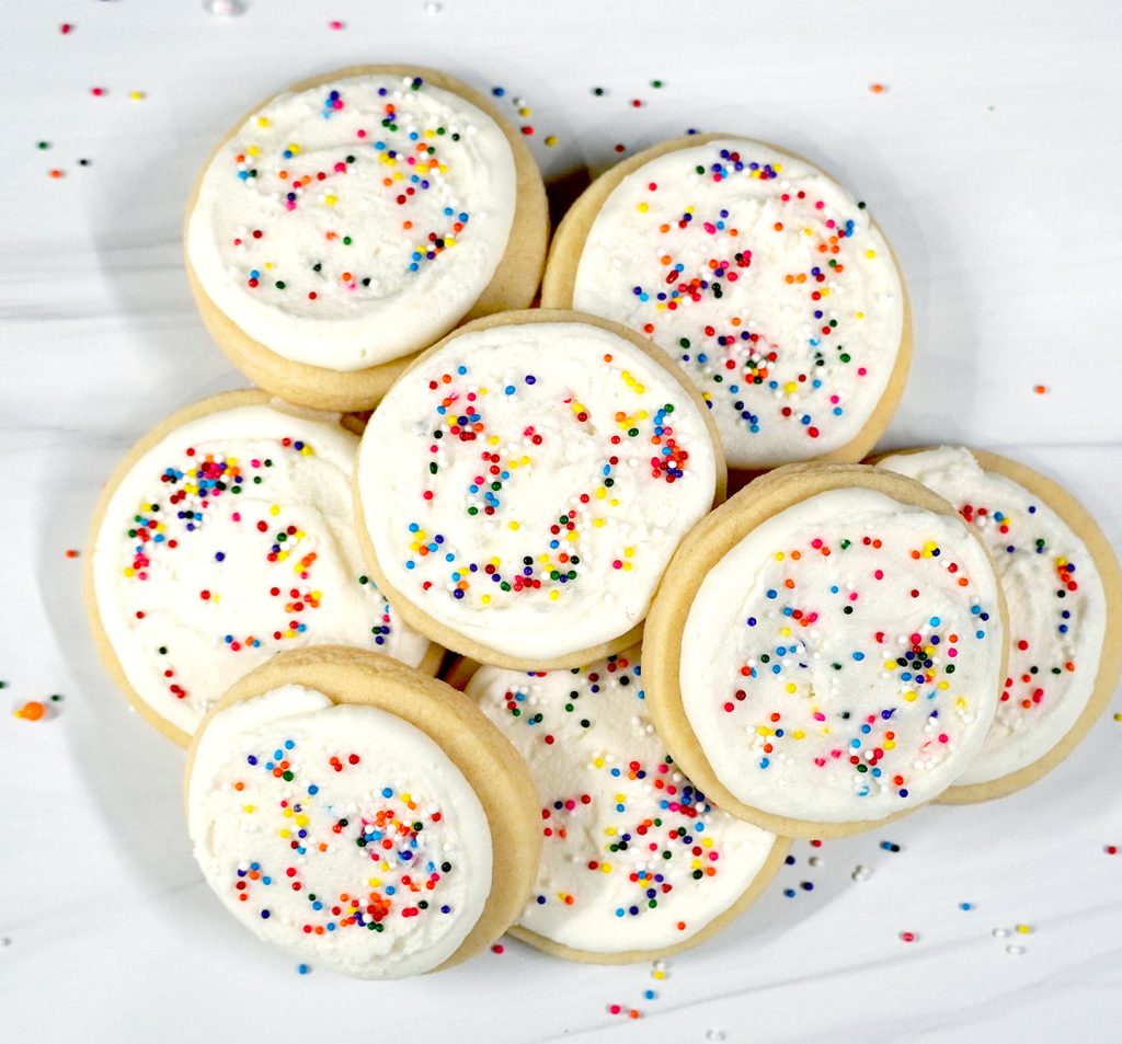 cut out sugar cookies with rainbow sprinkles in pile