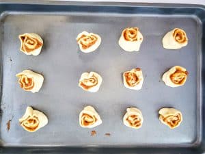 pumpkin pie crescent roll pinwheels on a cookie sheet
