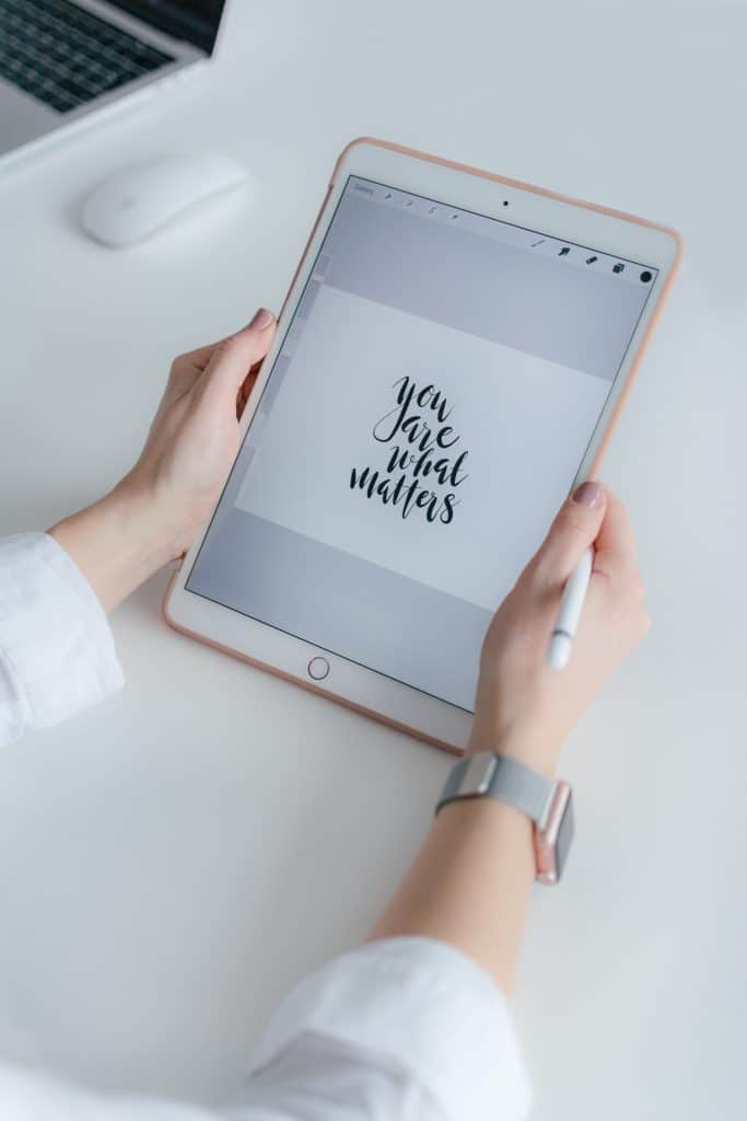 woman holding gold ipad with procreate app