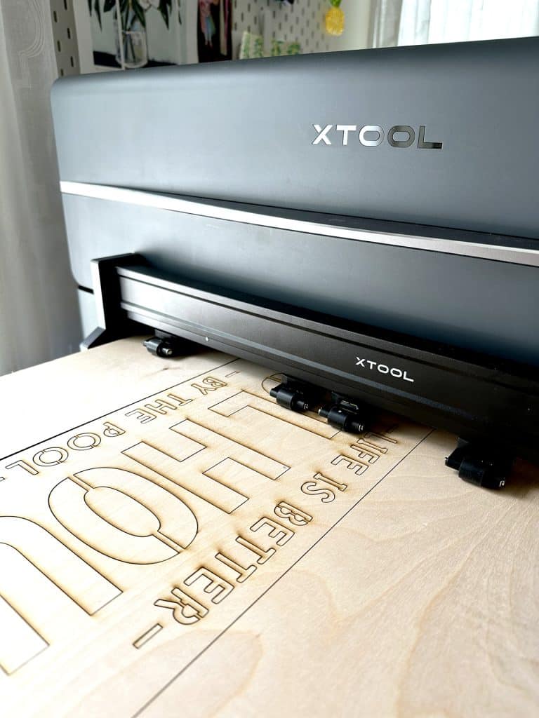 xtool p2 cutting large wood sign with automatic conveyor feeder