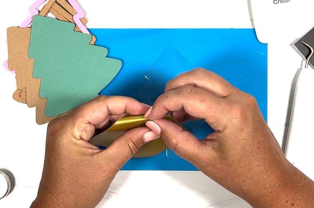removing gold vinyl pieces for diy shaker christmas ornaments