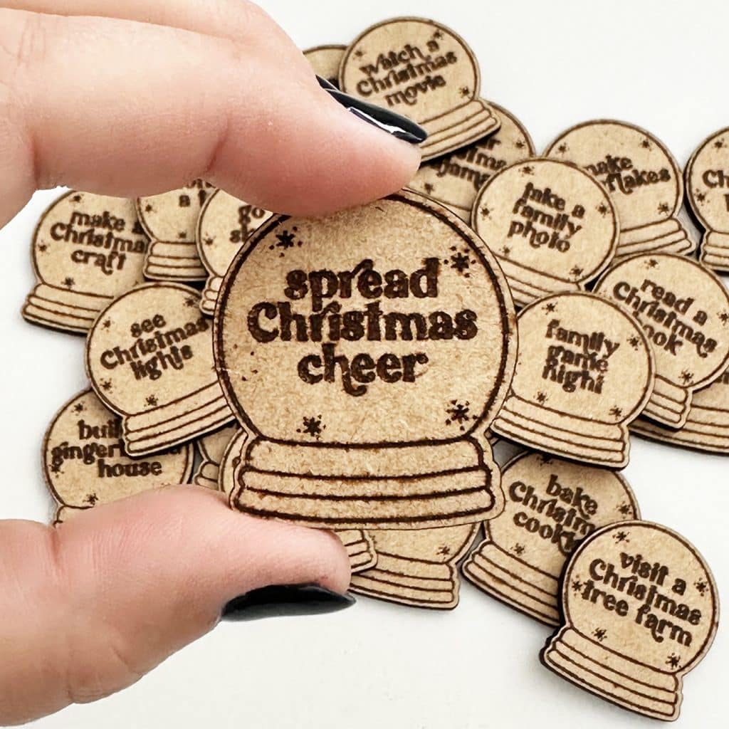 diy lsaer christmas activity tokens with hand holding one for close up