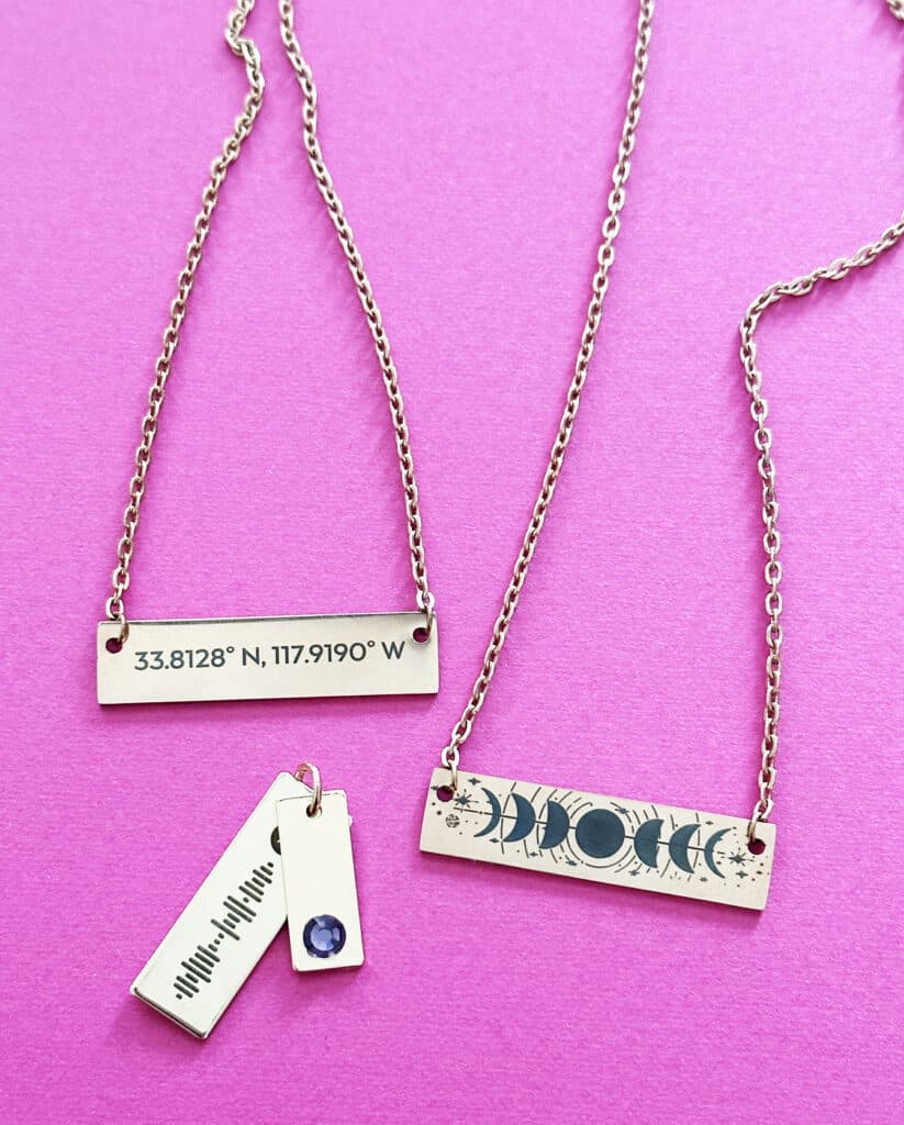 laser engraved necklaces on pink background