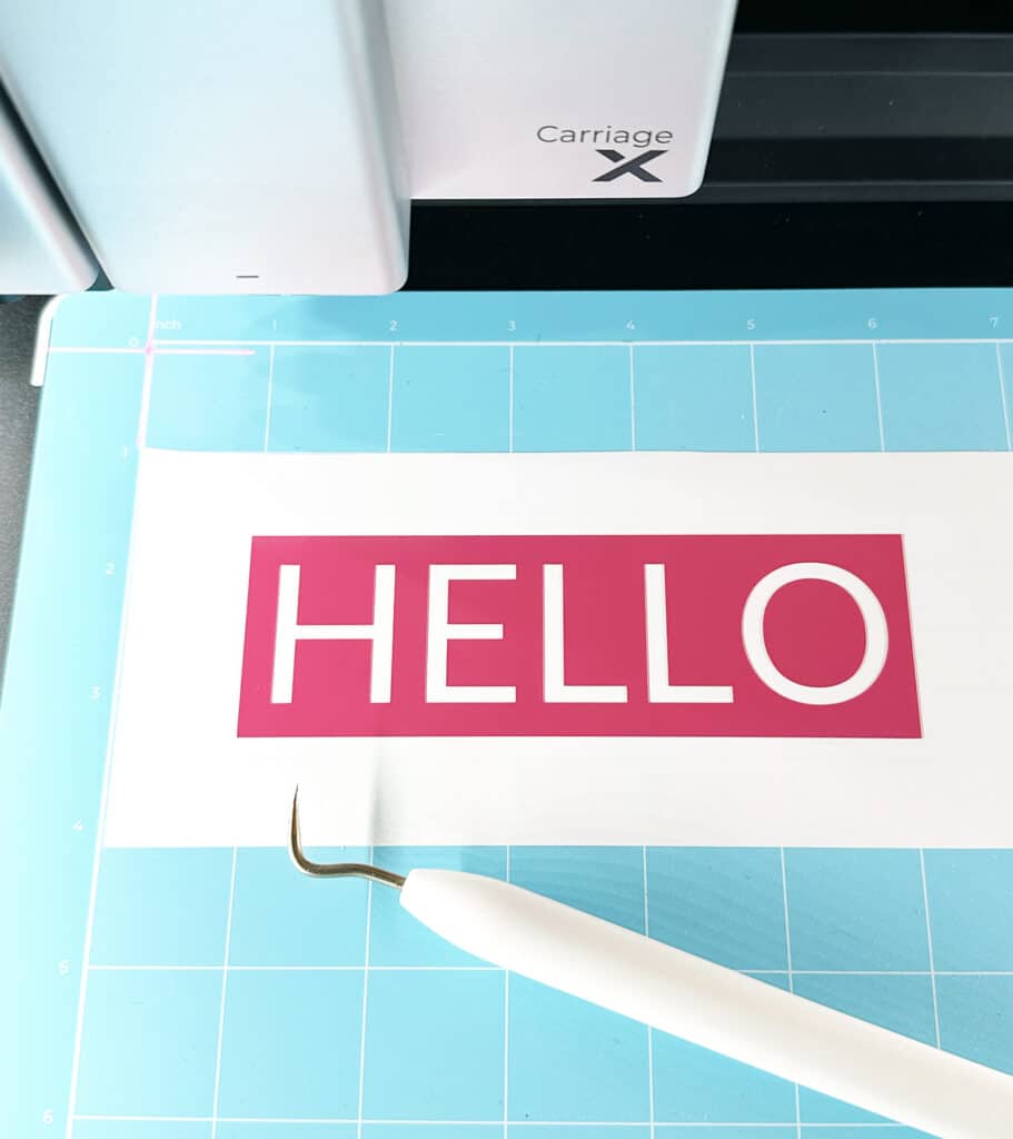 weeded hot pink vinyl hello on cutting mat inside xtool m1 ultra